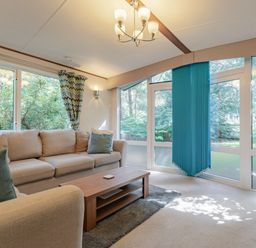 A living room with a sofa and coffee table at Fern View -Kelling Heath Holiday Park in Weybourne near Sheringham