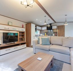 A living room with a television and sofa at Fern View -Kelling Heath Holiday Park in Weybourne near Sheringham