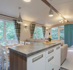 A living room with a sofa and dining area at Fern View -Kelling Heath Holiday Park, Weybourne near Sheringham
