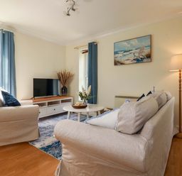 A living room with a television and sofa at Flat 5 in Looe