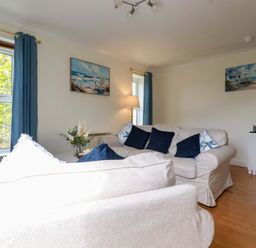 A living room with a sofa and lamp at Flat 5 in Looe