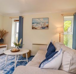 A living room with a sofa and television at Flat 5 in Looe