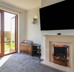 A living room with a fireplace and television at Carnweather in Newquay