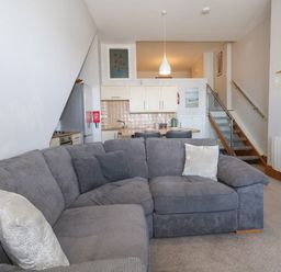 A living room with a sofa and kitchen area at Chandlers Nook in Portland