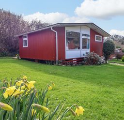 A house with windows and grass at Chalet 23 Erw Porthor Tywyn