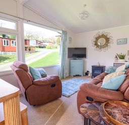 A living room with a sofa and television at Chalet 23 Erw Porthor Tywyn