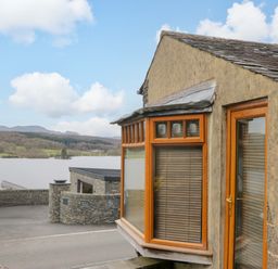 A house with windows overlooking a lake at Wilders Wood in Windermere