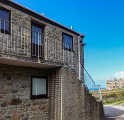 An exterior view of a building with a balcony and stairs at Cape View, Cape Cornwall near St Just