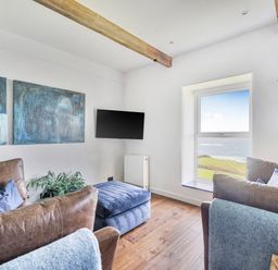 A living room with a television and a window at Cape View near St Just