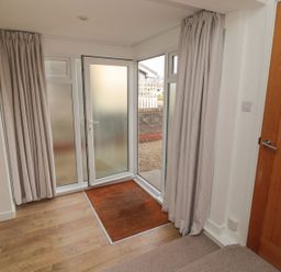 An entrance with a glass door and curtains at 7 Longstone Close Chathill