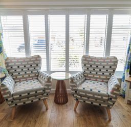 Two patterned chairs and a table with a view through the window at 7 Longstone Close Chathill