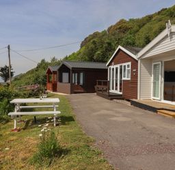 An outdoor area with cottages and a picnic table at Salt & Stone in Lyme Regis