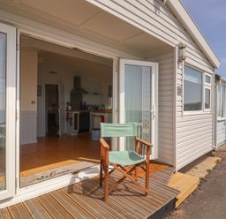 An outdoor area with a chair and kitchen view at Salt & Stone in Lyme Regis
