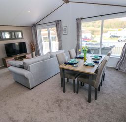 A living room with a sofa and dining area at Dukes Meadow in Carmarthen