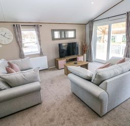 A living room with sofas and a television at Dukes Meadow in Carmarthen