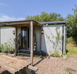 A hut with steps and a table outside at Daisy Shepherd's Hut in South Molton