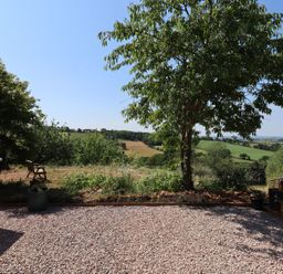 A view from a garden with a chair and tree at Nelli Lodge at Mile End, Crediton