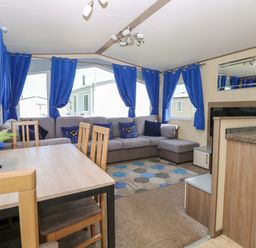 A living room with a sofa and dining area at PK Sunset View in Corton