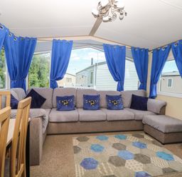 A living room with a sectional sofa and dining table at PK Sunset View in Corton
