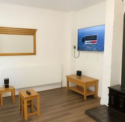 A living room with a mirror, television, and coffee table at Llangollen - House - Sleeps 8- Garden in Llangollen