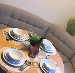 A dining table set with plates and glasses at Llanarmon-yn-Ial Mold 3-Bed Caravan, Sleeps 6 Llanarmon-Yn-Ial