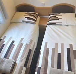 A bedroom with two single beds and a window at Llanarmon-yn-Ial Mold 3-Bed Caravan, Sleeps 6 Llanarmon-Yn-Ial