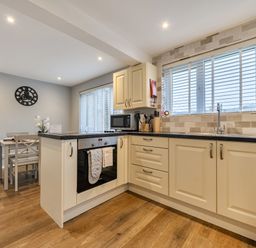A kitchen with appliances and dining area at 2 Bed House - Sleeps 4 - Garden - Parking - Wifi, Kendal