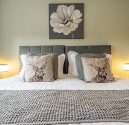 A bedroom with a bed and decorative pillows at 2 Bed House - Sleeps 4 - Garden - Parking - Wifi, Kendal