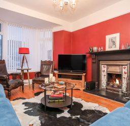 A living room with a fireplace and television at Rhiwlas in Rhosneigr