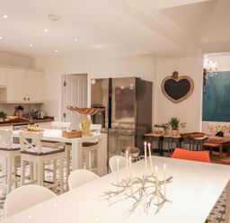 A kitchen with a table and chairs at Rhiwlas in Rhosneigr