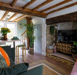 A living room with a sofa and television at Cotswolds Cozy Cottage Retreat - pet friendly, Finstock