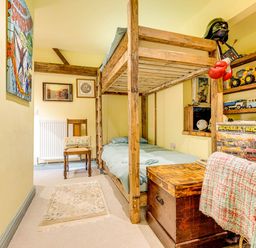 A bedroom with a bunk bed and toys on a shelf at Family Country Cottage with a private Valley View
