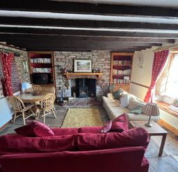 A living room with a sofa and dining table at Quiet cottage on the rural edge of Brixham