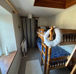 A bedroom with a bunk bed and window at Quiet cottage on the rural edge of Brixham