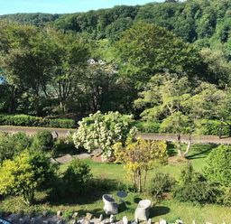 A garden with trees and benches at Beachside 2-Bed - Sleeps 4, Parking & Pet Friendly, Salcombe