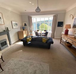A living room with a fireplace and sofa at Beachside 2-Bed - Sleeps 4, Parking & Pet Friendly, Salcombe