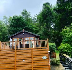 A lodge with decking and steps in a wooded area at 2 Bed Lodge-Sleeps 4-stunning views -Pet Friendly Troutbeck