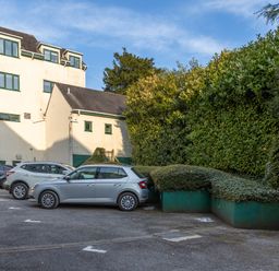 A parking lot with cars and greenery at Luxury 2 Bed Room Lake View Apt Bowness Parking Bowness-On-Windermere