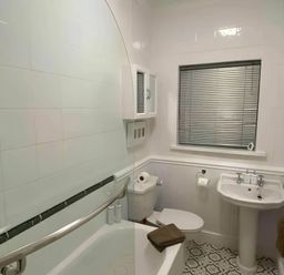 A bathroom featuring a bathtub, toilet, sink, and window at 4 Bed House-Sleeps 8-Parking-Pets-MarinaSeaView in Torquay