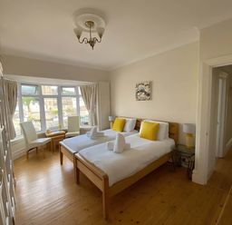 A bedroom with two single beds and a table at 4 Bed House-Sleeps 8-Parking-Pets-MarinaSeaView in Torquay