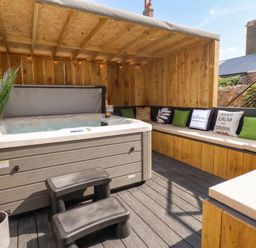 An outdoor area with a hot tub and seating at Sea View, East Parade, Llandudno