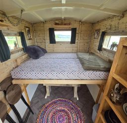 A bedroom with a bed and wooden decor at Restored circus wagon Saltburn-By-The-Sea