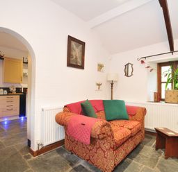 A living room with a sofa and lamp at Coach House, Camelford