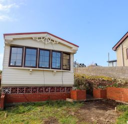 A caravan structure with windows outside at Caravan at Argraig Llanrhyddlad near Cemaes Bay