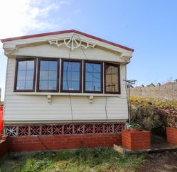 A mobile home with windows and bricks at Caravan at Argraig Llanrhyddlad near Cemaes Bay