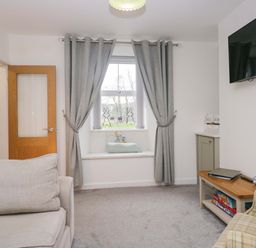 A living room with a window and sofa at Bobtail Cottage in Kendal