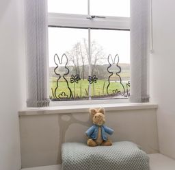 A bedroom with a stuffed toy on a blanket at Bobtail Cottage in Kendal
