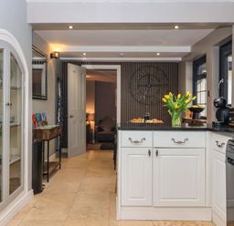 A kitchen with an island and a vase of tulips at Blacksmiths Retreat in York