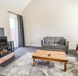A living room with a sofa and coffee table at Elwy Cottage in St Asaph