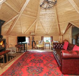 A living room with a fireplace and sofa at Antlers Lodge in Biddulph Moor